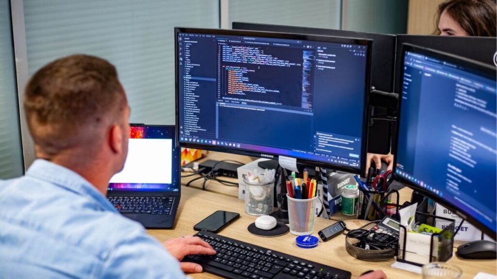 Člen týmu Sales House Group pracuje u počítače v kanceláři a představuje práci v IT a office oddělení.