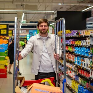 Členové týmu Sales House Group si pořizují společnou fotografii v prodejně a ukazují přátelskou atmosféru v oblasti merchandisingu a sales.