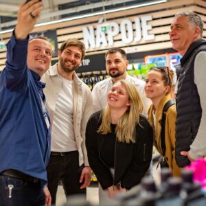 Členové týmu Sales House Group si pořizují společnou fotografii v prodejně a zachycují přátelskou atmosféru při práci v terénu.