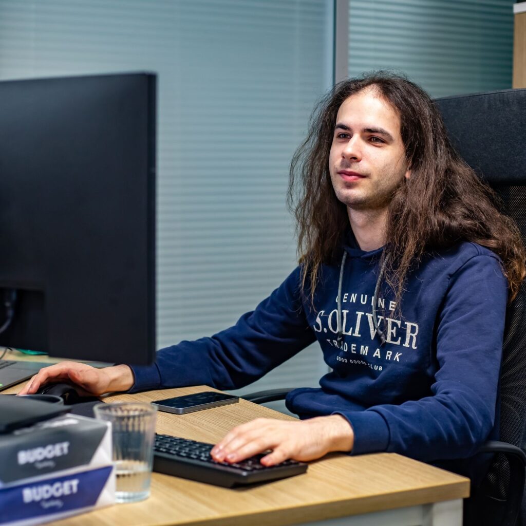 Člen týmu Sales House Group pracuje u počítače v kanceláři a představuje IT a office podporu firmy.
