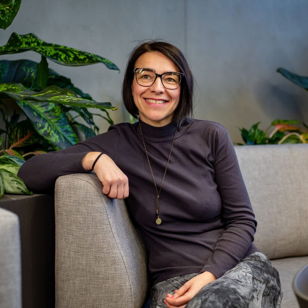 Členka týmu Sales House Group sedí v kancelářském zázemí a představuje přátelskou atmosféru office týmu.
